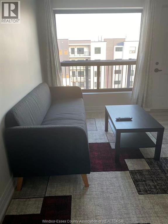 A living room with a grey couch and a black coffee table.