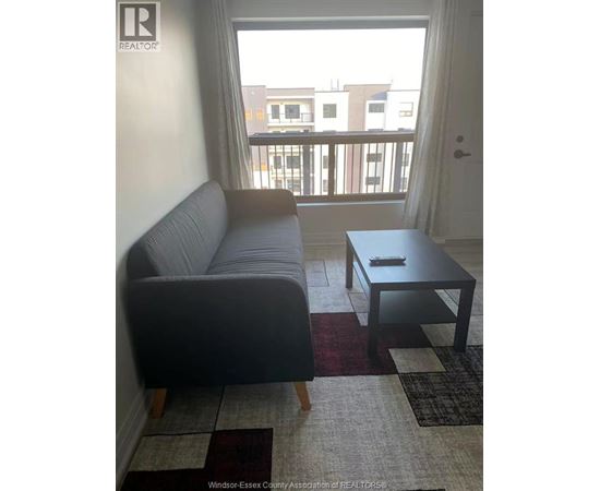 A living room with a grey couch and a black coffee table.