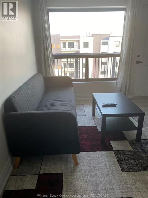 A living room with a grey couch and a black coffee table.
