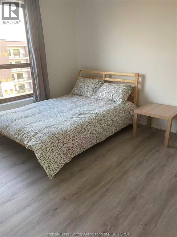 A bedroom with a bed, pillows, and a small table.