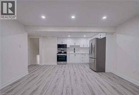 A spacious kitchen with white cabinets and stainless steel appliances.