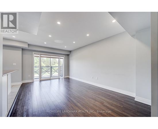 A spacious room with wooden flooring and a sliding glass door leading outside.