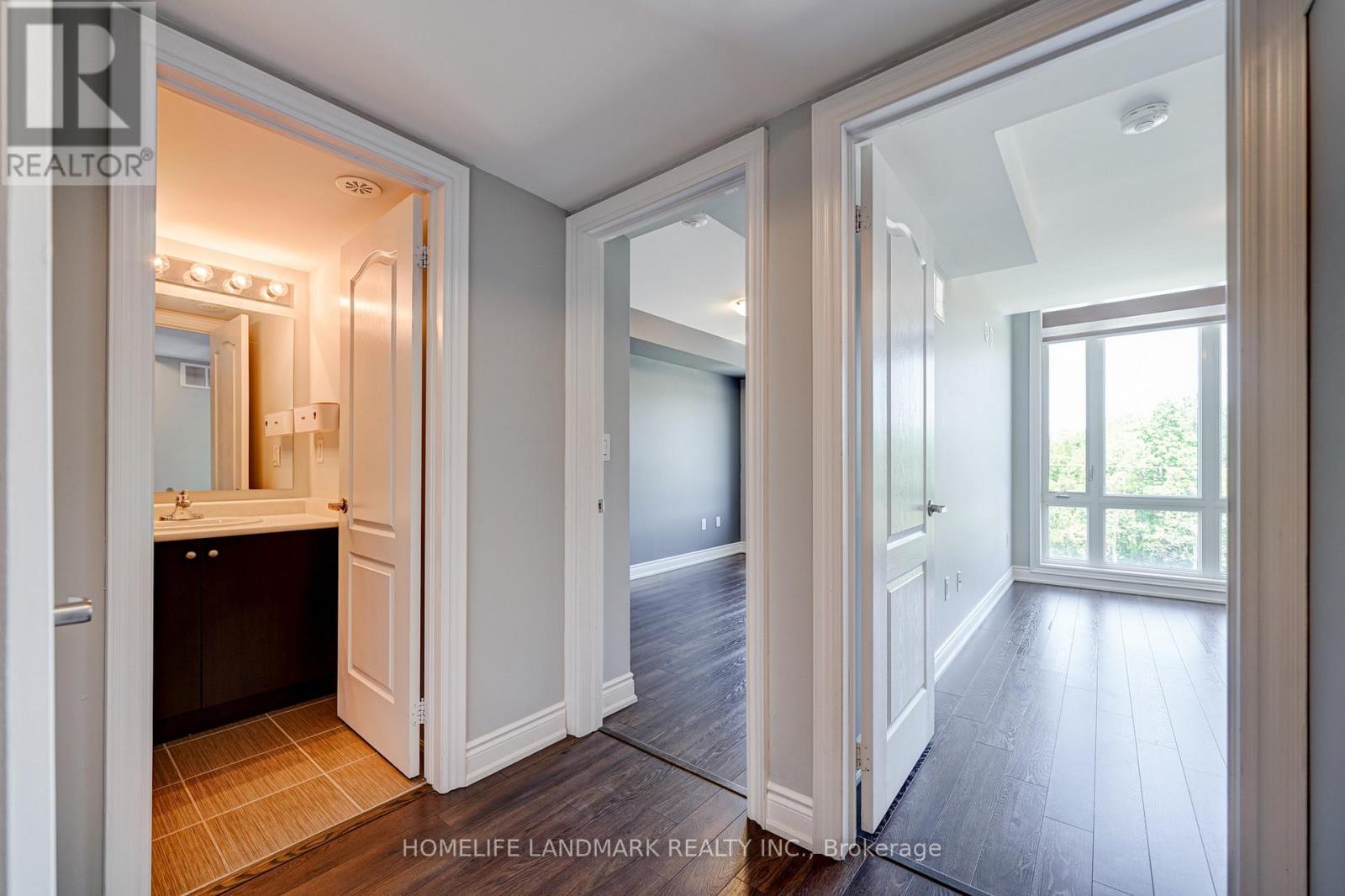 A realtor photo of a home interior with a bathroom, a hallway, and a bedroom.