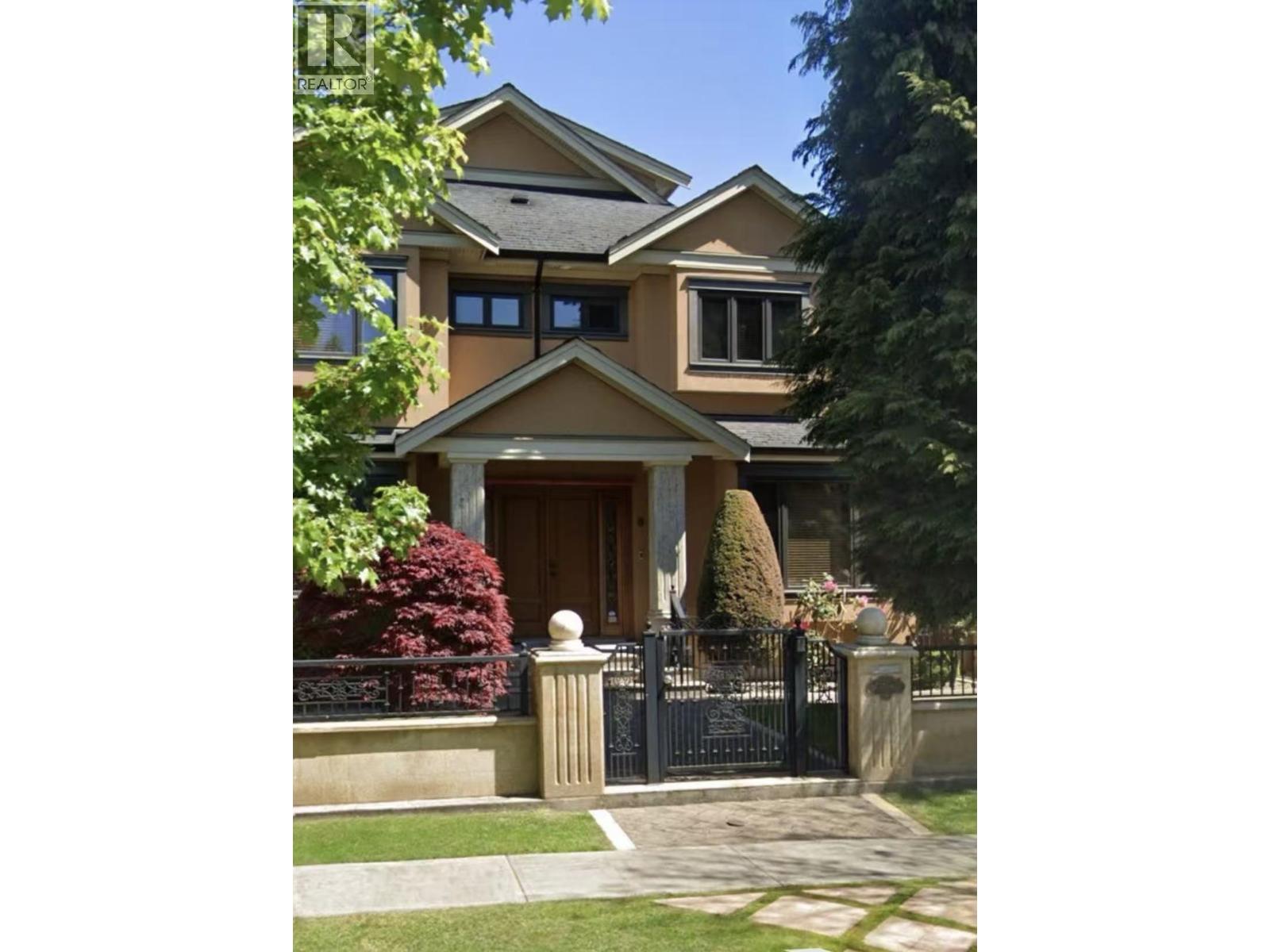 A house with a black gate and a brown door.