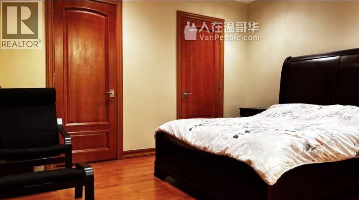 A bedroom with a bed, chair, and a door with a sign on it.