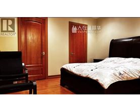 A bedroom with a bed, chair, and a door with a sign on it.