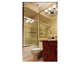 A bathroom with a toilet, sink and mirror.