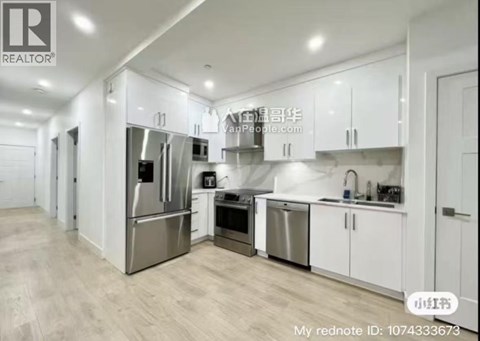 A modern kitchen with white cabinets and stainless steel appliances.