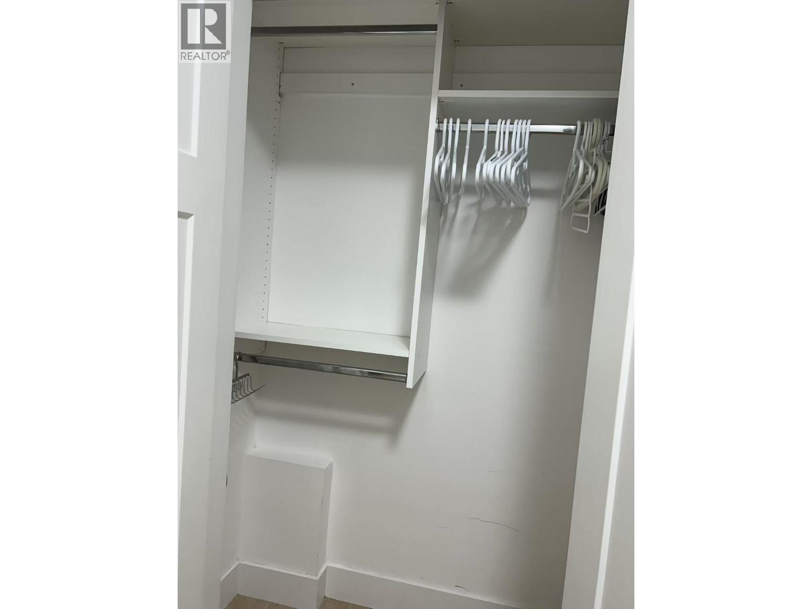 A white closet with a hanging rod and shelf.
