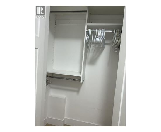 A white closet with a hanging rod and shelf.