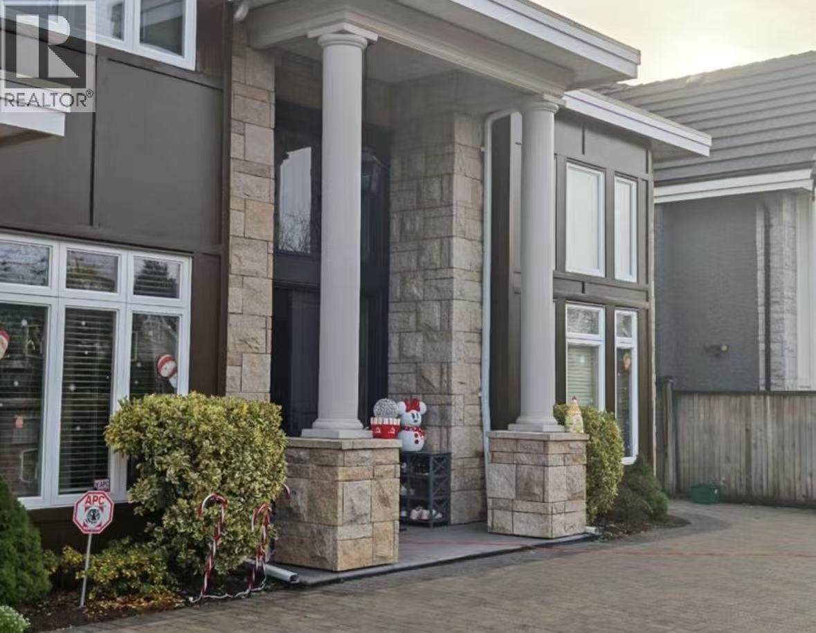A house with a brown and white facade has a sign that says "For Sale".