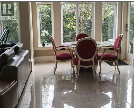A dining room with a table and chairs.