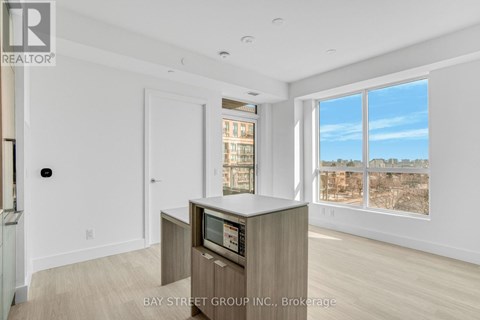 A spacious living room with a television and a view of the city.