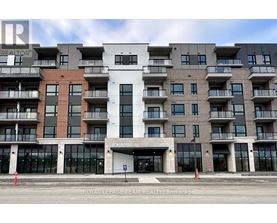 A large, modern apartment building with a white entrance and balconies on each floor.
