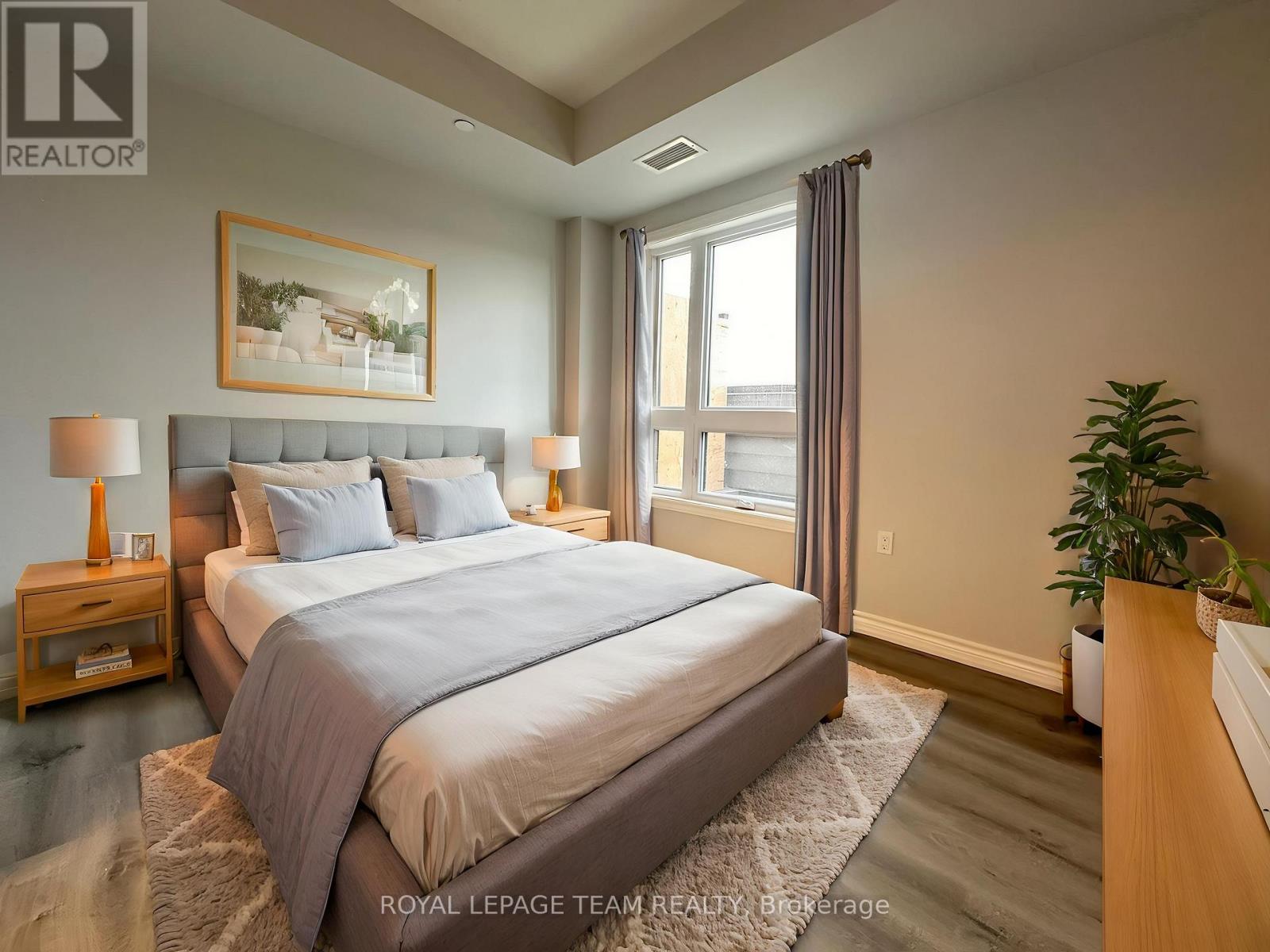 A bedroom with a large bed and a painting on the wall.