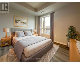 A bedroom with a large bed and a painting on the wall.