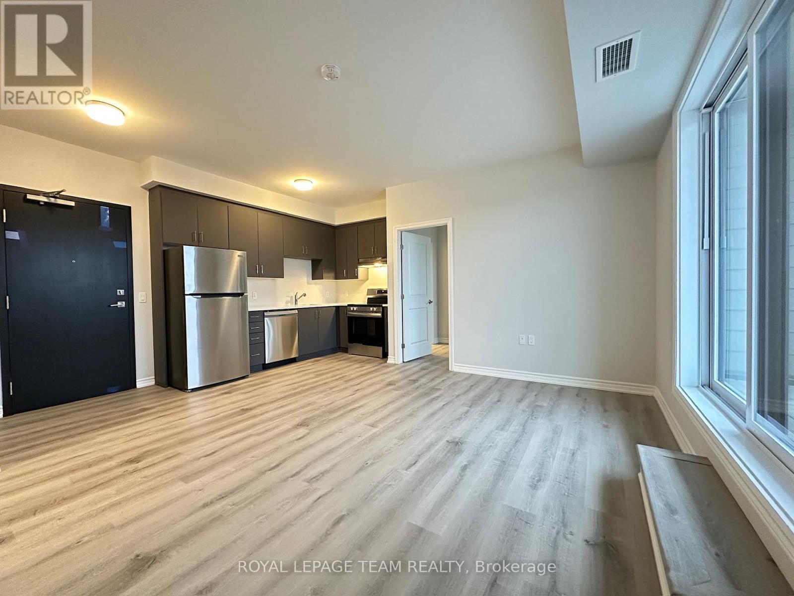 A spacious kitchen with dark wood cabinets and stainless steel appliances.