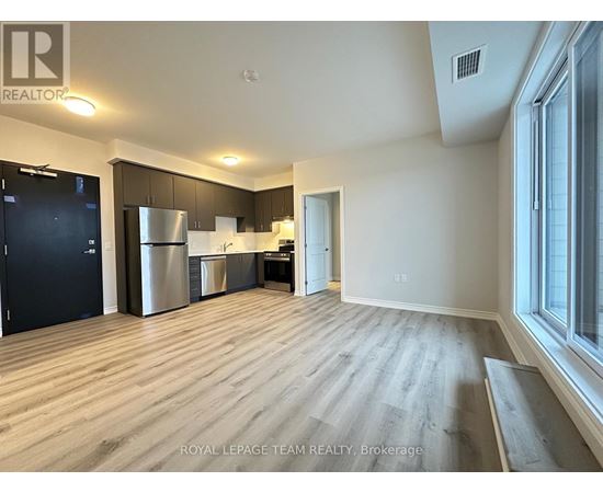 A spacious kitchen with dark wood cabinets and stainless steel appliances.
