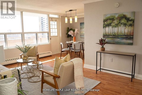 A living room with a painting of a forest on the wall.