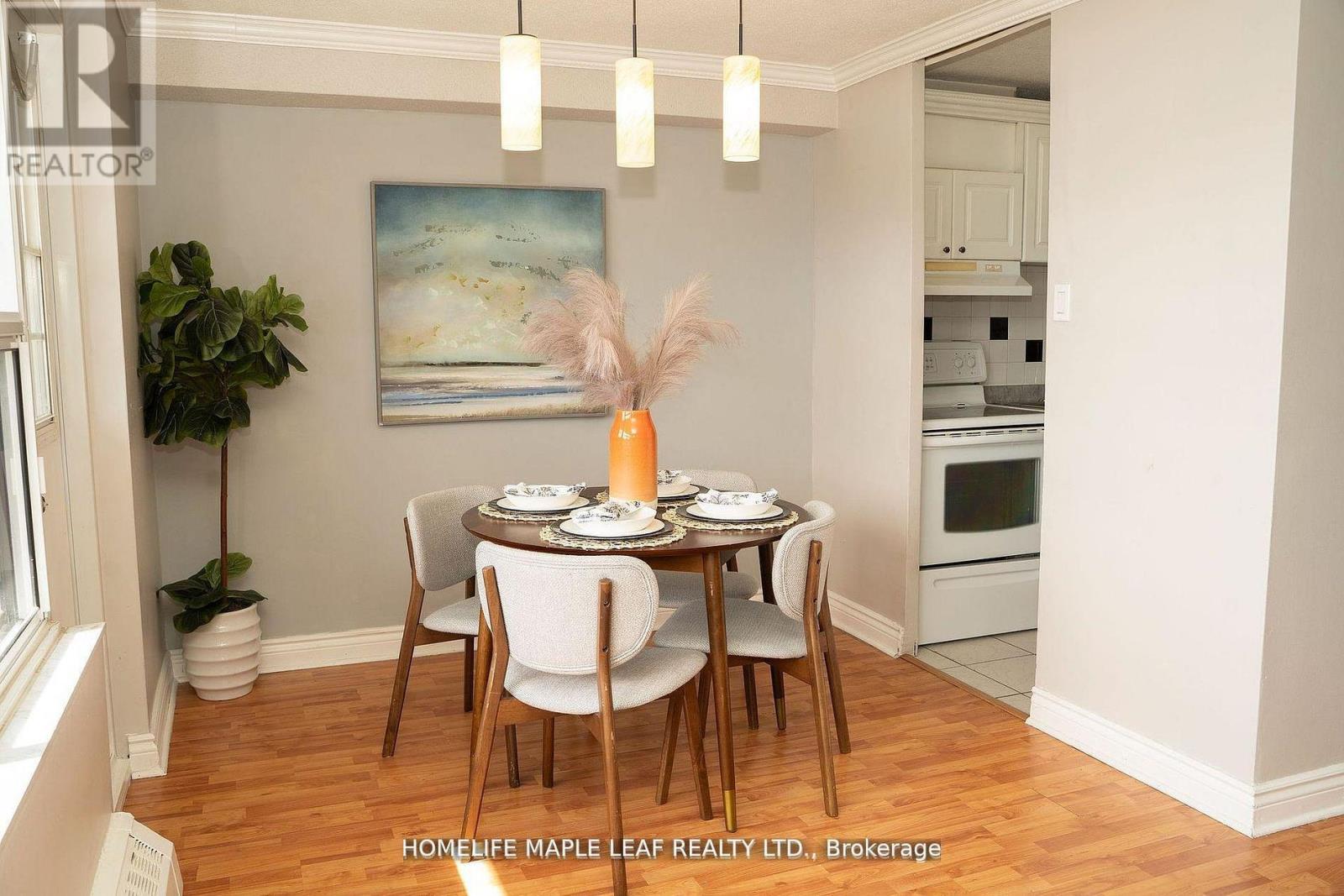 A dining room with a table set for two and a painting on the wall.