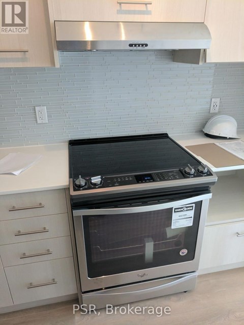 A stainless steel oven with a black top is in a kitchen.