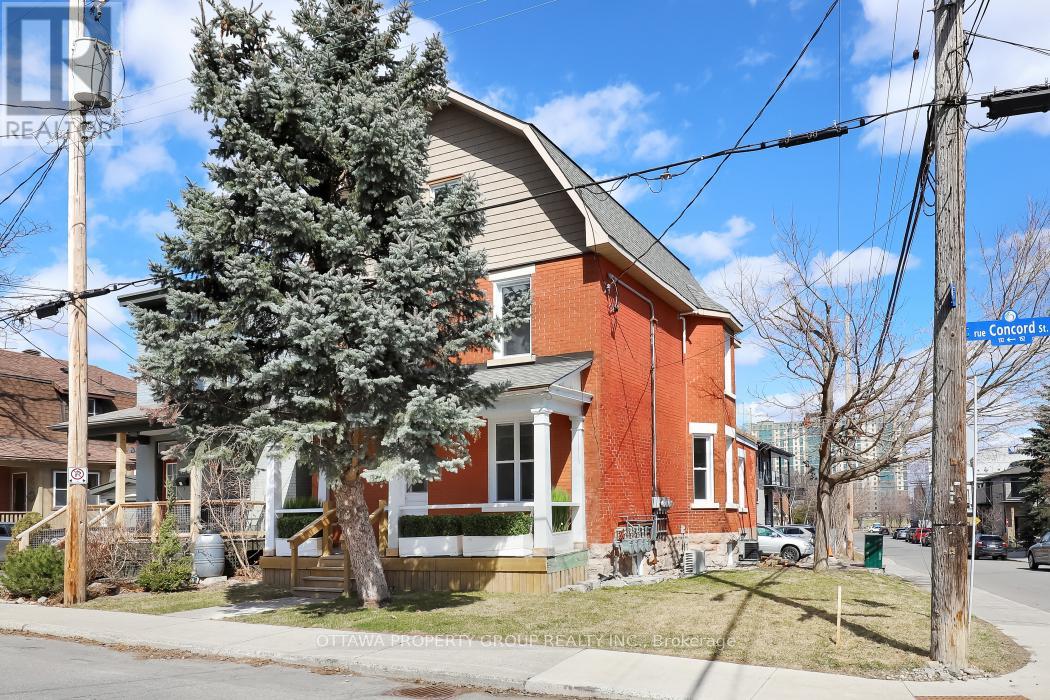 A red brick house with a tree in front.