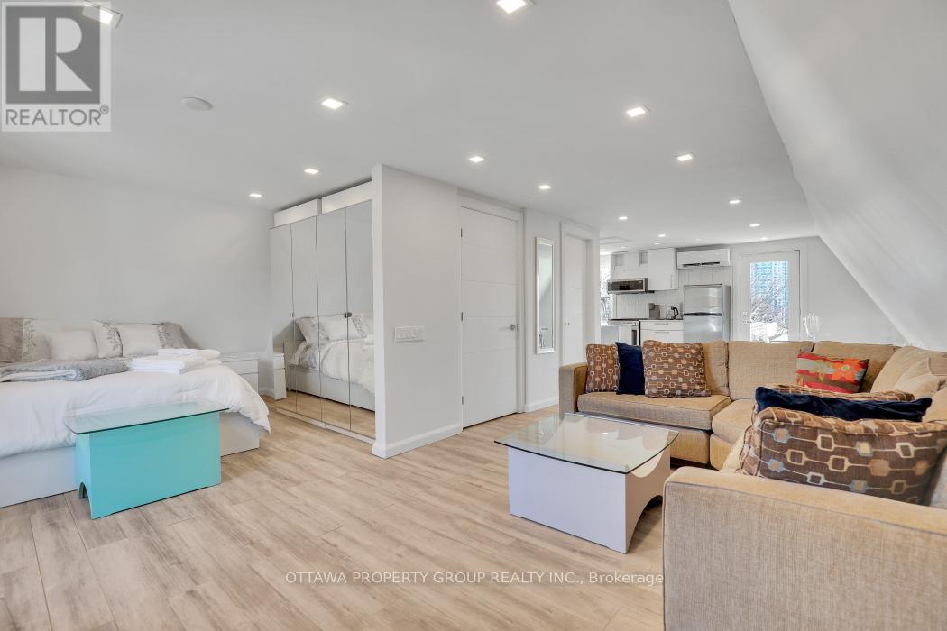 A well-lit, modern bedroom with a large bed and a separate sitting area.
