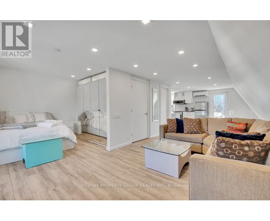 A well-lit, modern bedroom with a large bed and a separate sitting area.