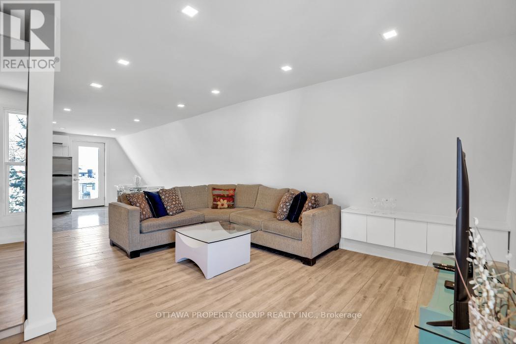 A living room with a couch, a coffee table, and a flat screen TV.
