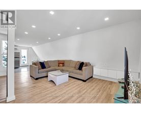 A living room with a couch, a coffee table, and a flat screen TV.