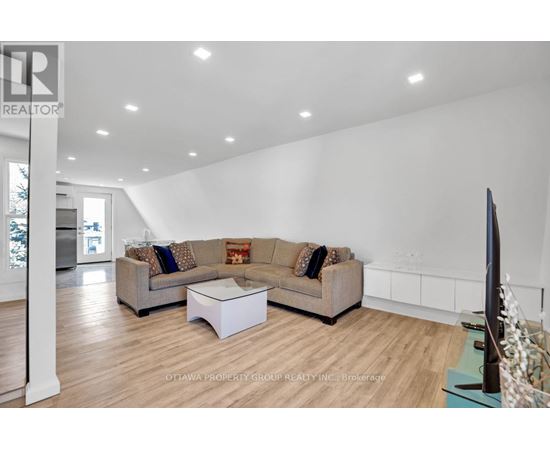 A living room with a couch, a coffee table, and a flat screen TV.