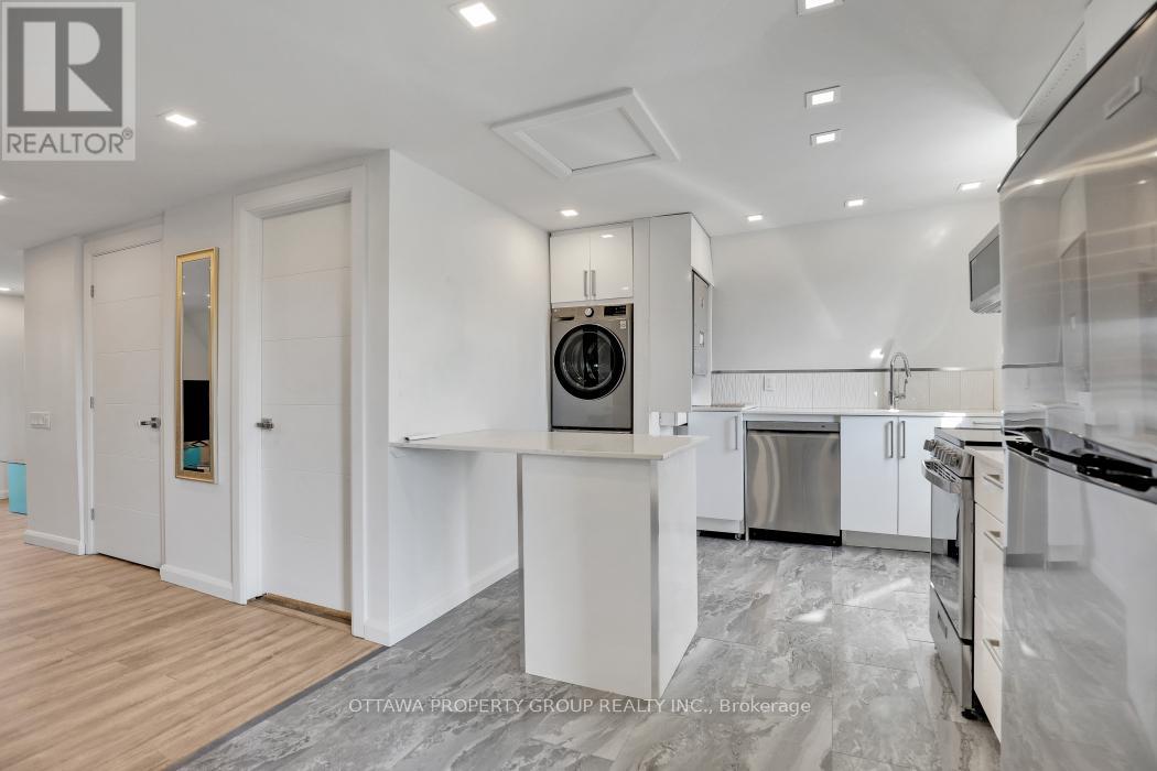 A modern kitchen with white cabinets and stainless steel appliances.