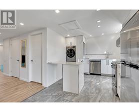 A modern kitchen with white cabinets and stainless steel appliances.