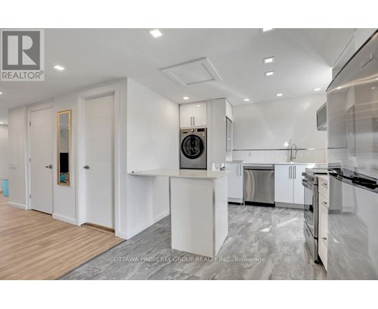 A modern kitchen with white cabinets and stainless steel appliances.