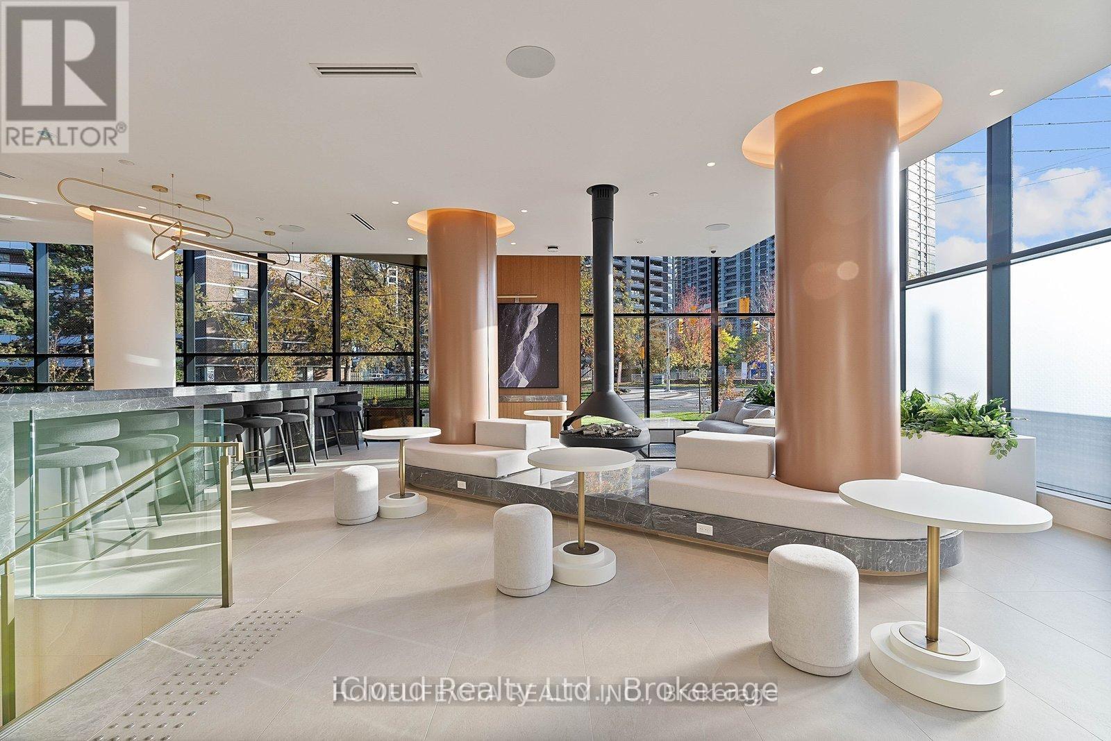 A modern office space with a glass railing, white furniture, and large windows.