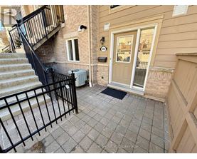 A front porch with a black railing and a white door.