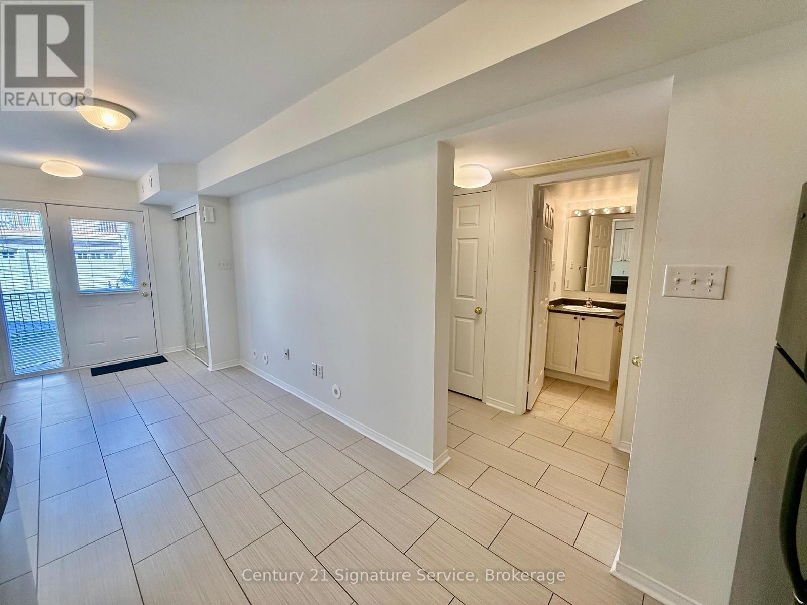 A spacious room with a kitchen area in the back.