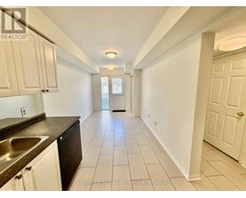 A long hallway with white walls and tile flooring.
