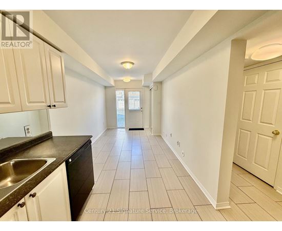 A long hallway with white walls and tile flooring.