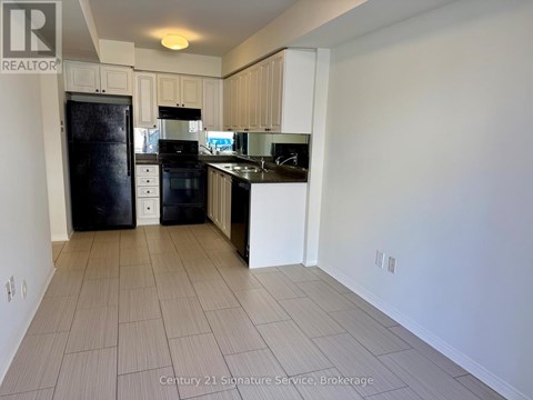 A kitchen with white cabinets and black appliances.