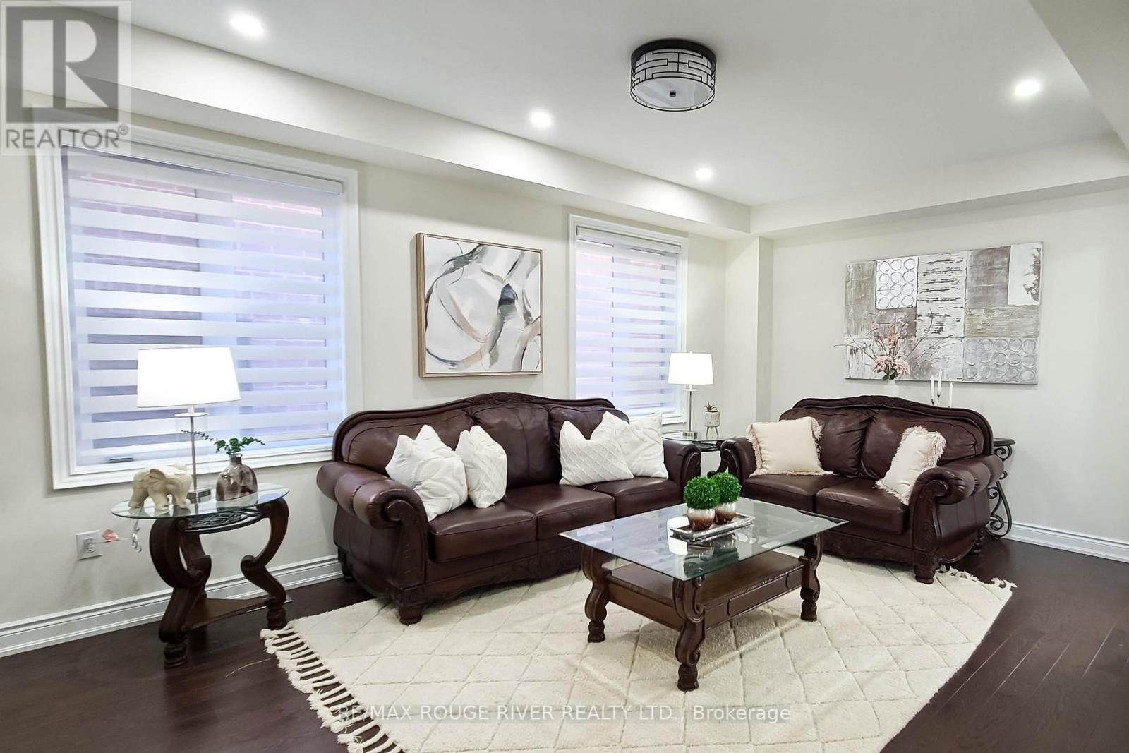 A living room with brown leather couches and a glass coffee table.