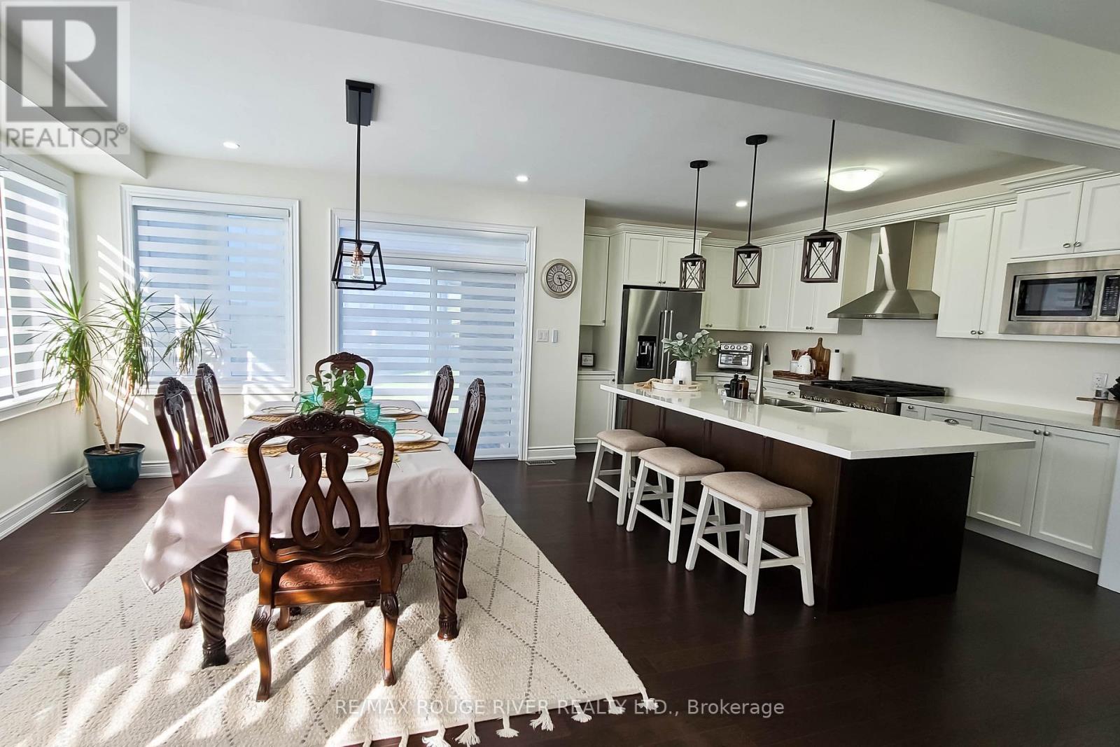 A dining room with a table set for two and a kitchen area in the background.