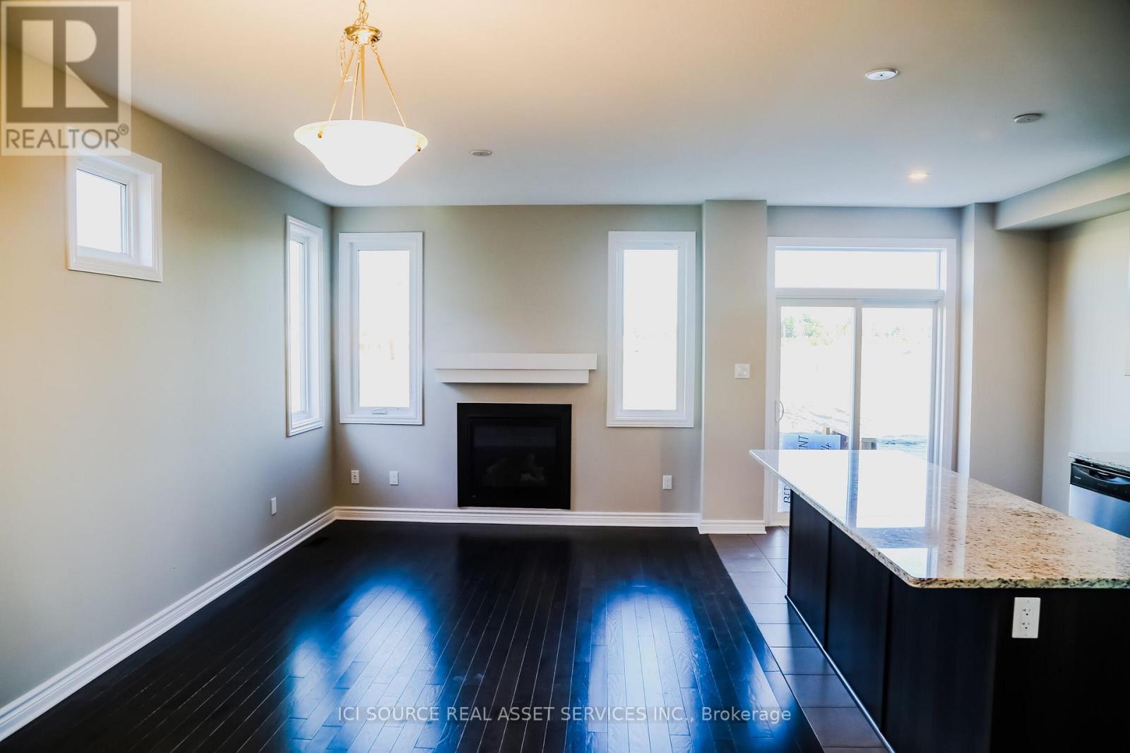 A well-lit, spacious living room with a fireplace and a large window.