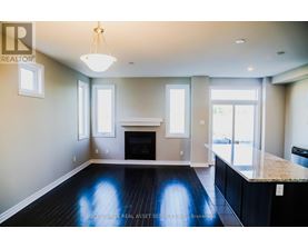 A well-lit, spacious living room with a fireplace and a large window.