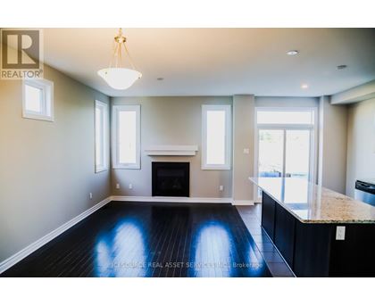 A well-lit, spacious living room with a fireplace and a large window.