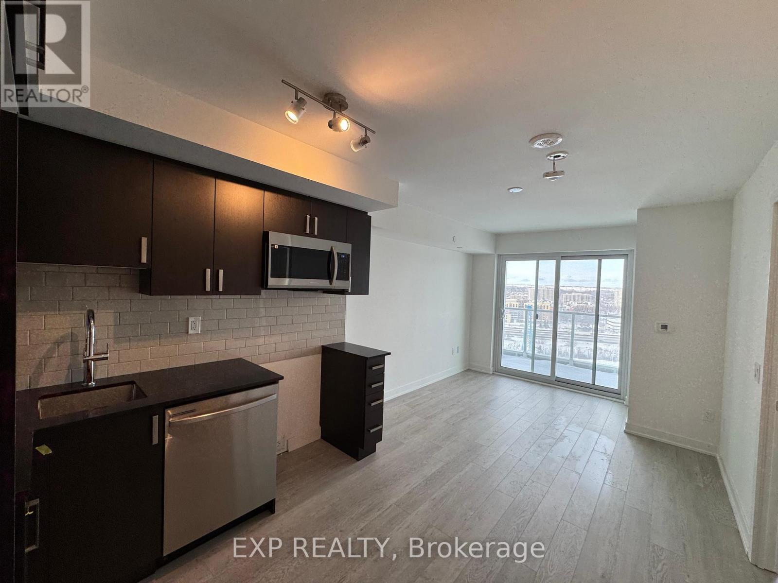 A kitchen with dark wood cabinets and stainless steel appliances.