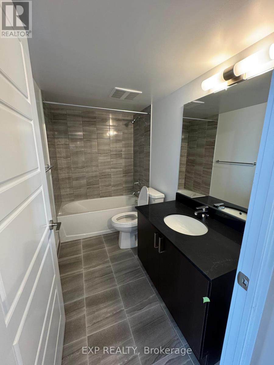 A bathroom with a toilet, sink, and bathtub.