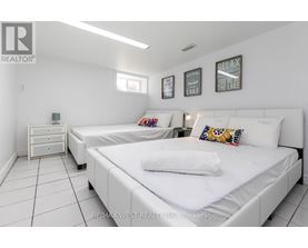 A bedroom with two beds and a nightstand.
