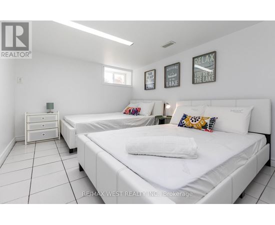A bedroom with two beds and a nightstand.