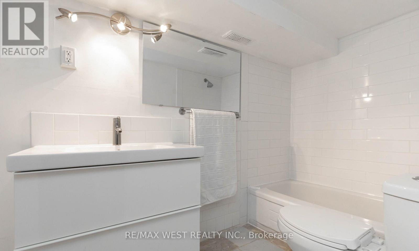 A white bathroom with a sink, toilet, and bathtub.